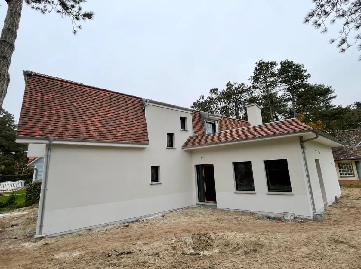 Maison rénovée avec enduit clair et toiture en tuiles neuve