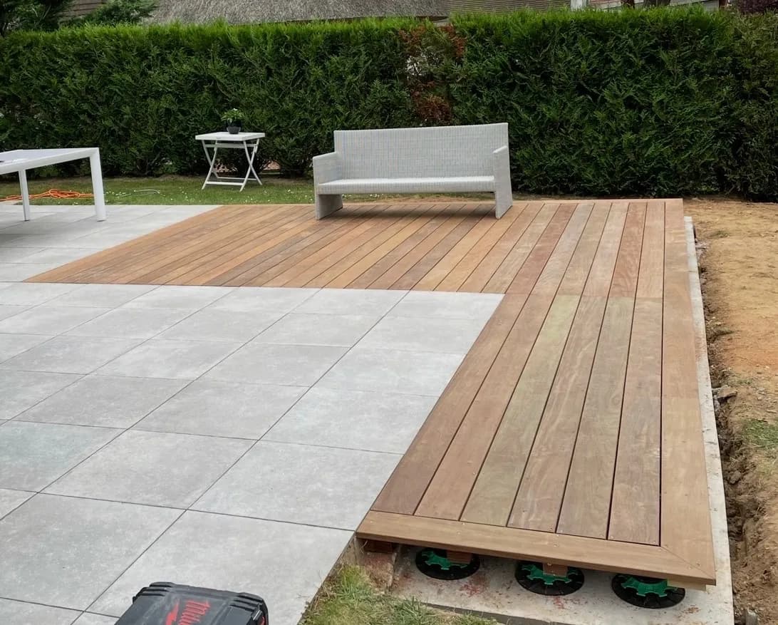 Terrasse en lames de bois exotique attenante à une terrasse carrelée en grès cérame